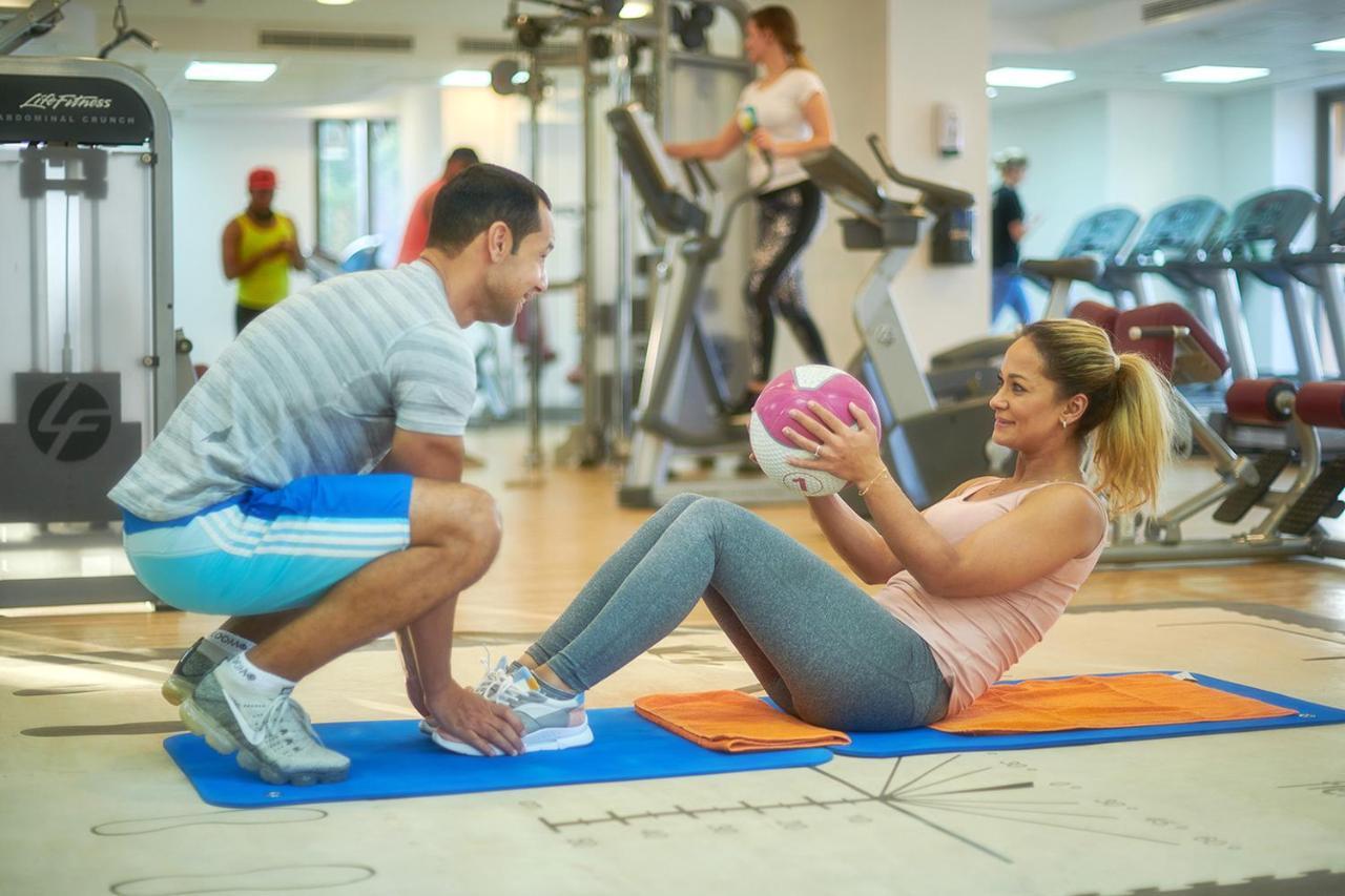 Bahi Ajman Palace Hotel Exterior foto Personal trainer assisting a woman with sit-ups